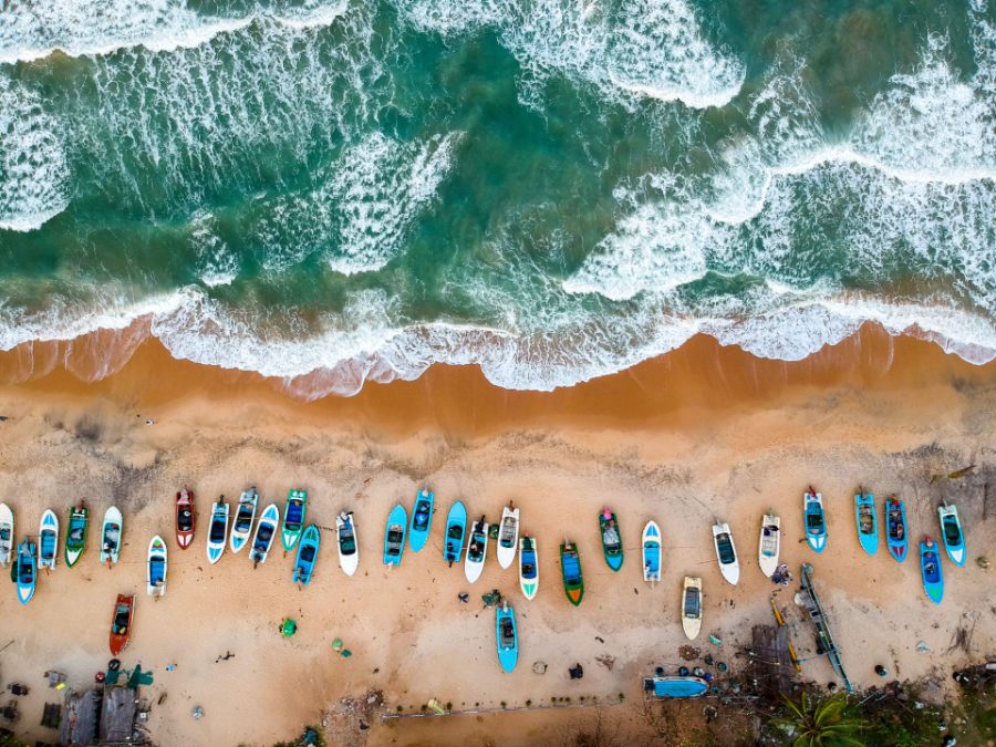 Barques de pêche alignées sur la plage, vues du ciel