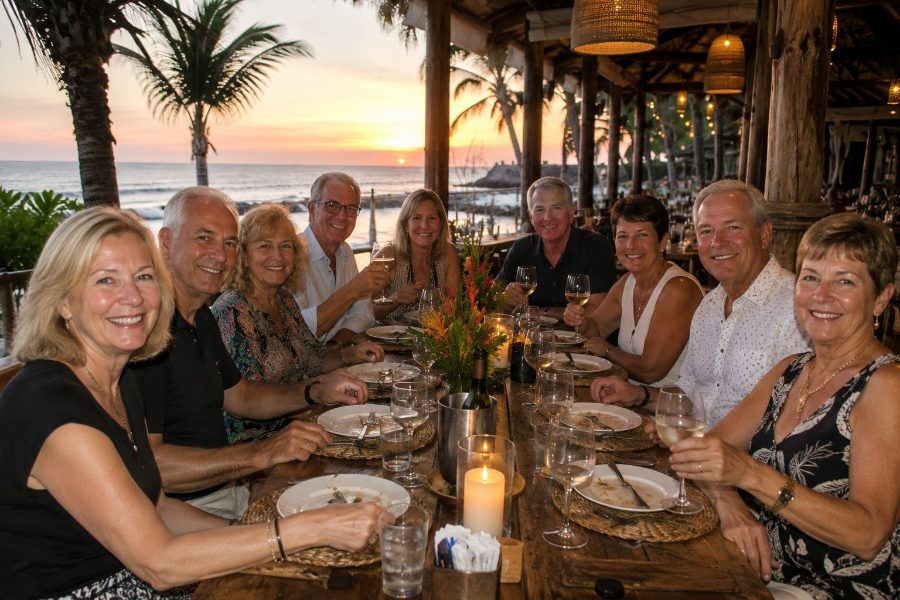 Souper de groupe au bord de l'eau au coucher du soleil